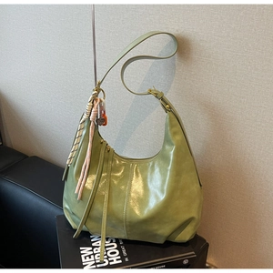 Détail du sac d'épaule en cuir verni vert avocat avec corde tissée et pompon décoratif