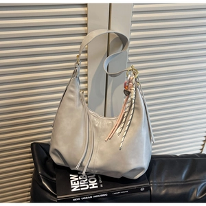 Détail du sac hobo gris clair avec pampille à franges et pendentif en corde tressée