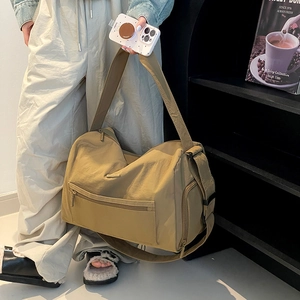 Detailansicht der khakifarbenen Nylon-Reisetasche mit Seitenfach und breitem Schultergurt