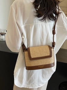Fashionable straw crossbody bag with contrast leather trim and knotted shoulder strap
