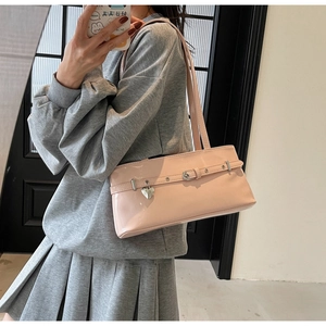 Mirror selfie showing a light pink patent leather baguette bag with a heart charm