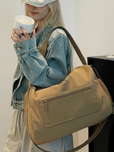 Große khakifarbene Reisetasche aus Nylon für Freizeit und Sport am Modell gezeigt
