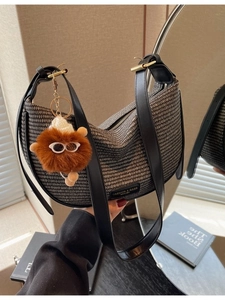 Chic black and white woven crescent bag with leather strap and plush toy charm