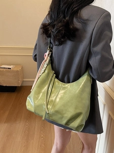 Grand sac hobo en cuir vert vif avec bandoulière tissée porté par un mannequin