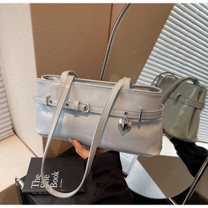 Detail of light blue leather underarm bag with silver heart pendant and buckle accents