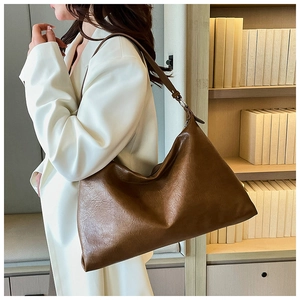 Brown leather tote bag with lychee texture shown on shoulder for daily commute look