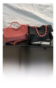 Détail de sacs à bandoulière en nylon rose et noir avec poignées tissées colorées
