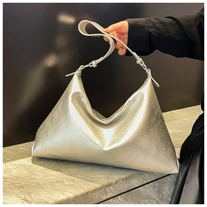 Detailed close-up of metallic silver tote bag texture with adjustable wide strap