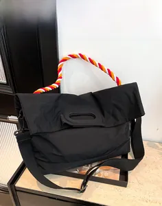 Détail du grand sac cabas noir avec anses spirales tressées rouges et oranges