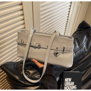 Detail of light blue patent leather underarm bag with silver heart charm and buckle