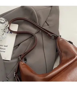 Detail view of dark brown faux leather shoulder bag with sleek metal zipper and slim strap