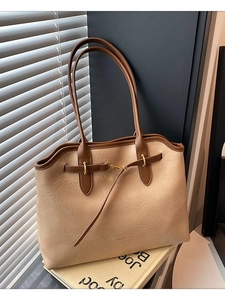 Large beige tote bag with brown trim and gold buckle, stylish minimalist commute handbag