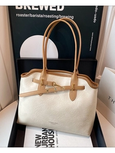 Minimalist beige leather tote bag with brown contrast trim shown in a stylish gift box