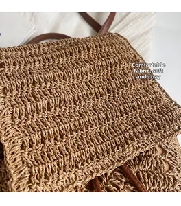 Detail of woven straw backpack showing soft brown texture and leather shoulder straps