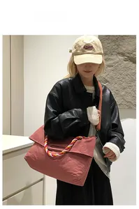 Détail d'un sac cabas en nylon rose rétro avec des anses en corde tressée colorée
