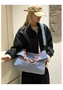 Détail du sac cabas en nylon bleu clair avec poignées tressées et bandoulière réglable