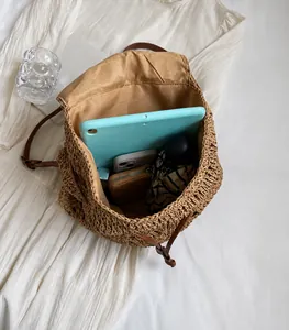 Interior detail of large straw backpack showing space for tablet, phone, and umbrella