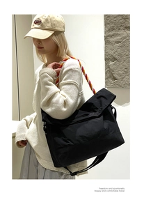 Détail du grand sac bandoulière noir avec une bandoulière en corde tressée colorée