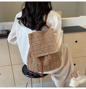 Rear view of model wearing a stylish woven straw backpack with leather straps and drawstring