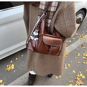 Detail of vintage brown tote bag with plush puppy pendant and silk scarf accent