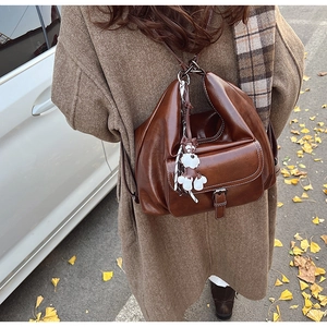 Detail of vintage brown oil wax leather backpack with contrast stitching and dog charm