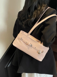 Pink patent leather underarm bag with silver heart pendant and decorative buckle detail