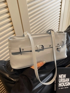 Glossy grey patent leather baguette bag with metal heart charm and buckle detail