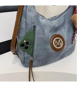 Dettaglio della tasca con cerniera della borsa in denim con spazio per smartphone