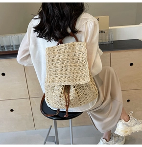 Detail of hand-woven straw backpack featuring hollow patterns and brown leather straps