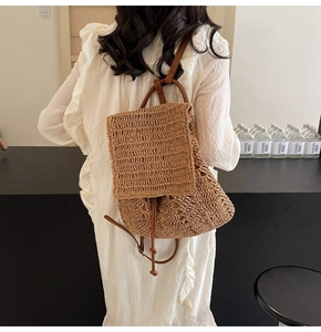 Detail view of woven straw backpack with leather straps and drawstring on model back