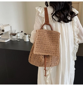 Detail of woven straw backpack with leather straps and drawstring closure for summer fashion