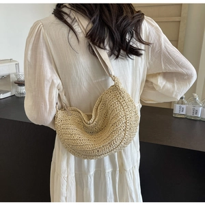 Dettaglio borsa hobo in paglia intrecciata beige con trama a uncinetto e tracolla comoda