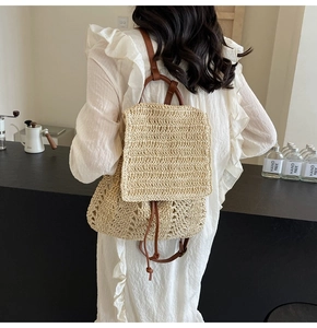 Macro shot of stylish beige straw backpack featuring brown leather straps and drawstrings