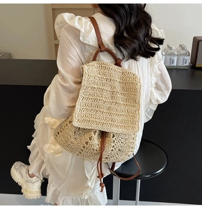 Detail of hand-woven straw backpack with brown leather drawstring and straps
