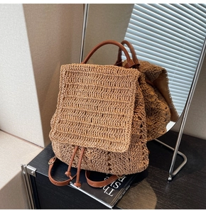 Detailed close-up of woven straw texture and brown leather strap on a summer backpack
