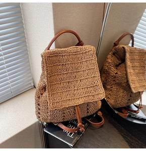 Detail view of woven straw backpack with brown leather straps and drawstring closure