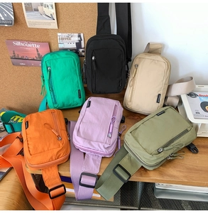 Close-up of nylon crossbody bags in six colors including emerald green and orange
