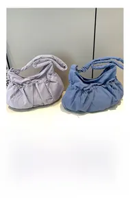 Detail of colorful nylon tote bags with drawstring sides and metal buckles for storage