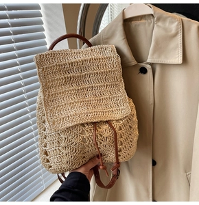 Detail of woven straw backpack showing natural texture, drawstring closure and leather straps