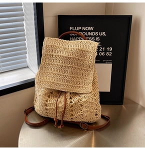 Detailed straw backpack with hollow crochet patterns and brown leather strap accents