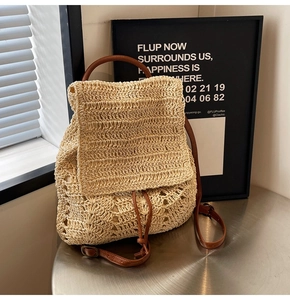 Detail of hand-woven straw backpack with brown leather straps and drawstring closure