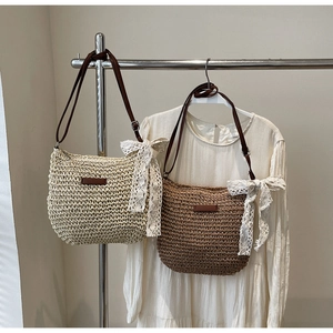 Detail of woven straw bags with large lace bows and brown leather straps in two colors