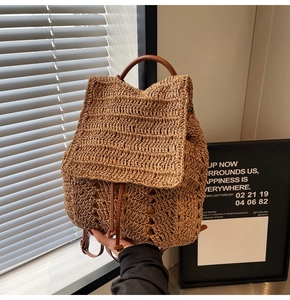 Detail of woven straw backpack showing natural texture and brown leather drawstring strap