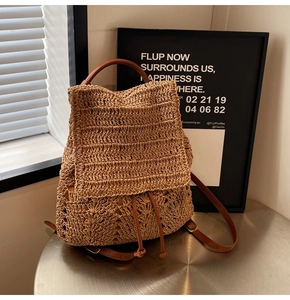 Detail of woven straw backpack with brown leather strap and fine crochet texture