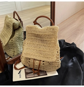 Detail of woven straw backpack with brown leather straps and drawstring closure