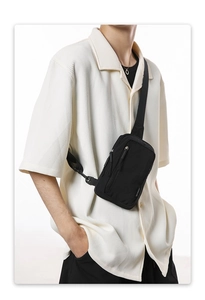 Close-up of black nylon crossbody chest bag showing water-resistant fabric and zippers