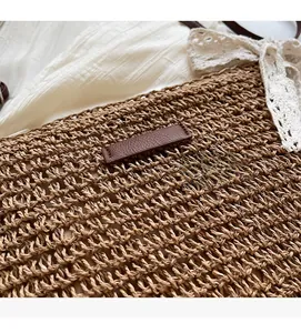 Close-up of dark brown woven straw bag with leather patch for summer vacations