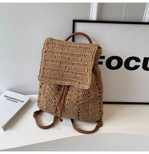 Macro detail of hand-woven straw texture and brown leather drawstring on a summer backpack