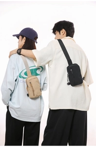 Detail view of khaki and black nylon crossbody bags showing adjustable shoulder straps