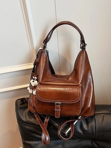 Vintage caramel brown oil-waxed leather backpack with white stitching and puppy charm